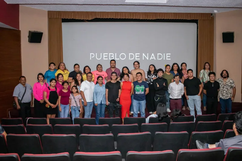 Grupo reunido frente a la proyección del título Pueblo de nadie